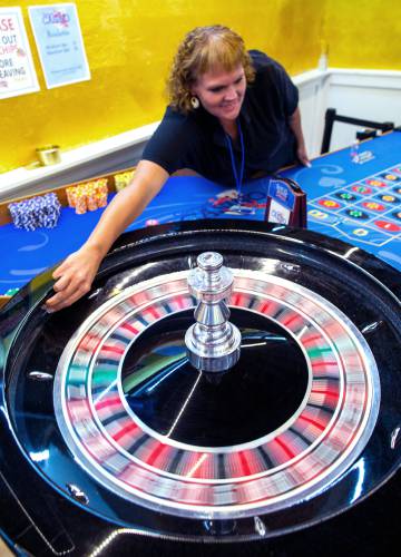 Dealer Jennifer Chalk gets ready to drop the ball at the roulette table at the casino in the basement of the Draft on Main Street in Concord earlier this month.