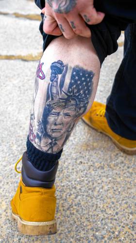 Chris Shaw shows his Donald Trump tattoo on his left calf outside the Pittsfield Middle High School on Tuesday.