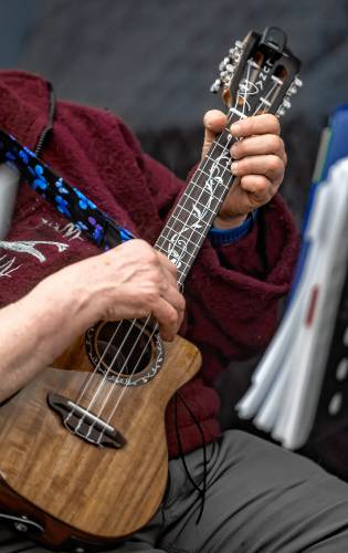 Laurel Flax tunes up the ukelehe before the group gathers for practice at the Hopkinton community room at the library on Tuesday, February 20.