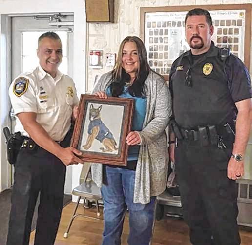 Ashley Turcotte (center)  with  a portrait she painted of the Barnstead police dog. 