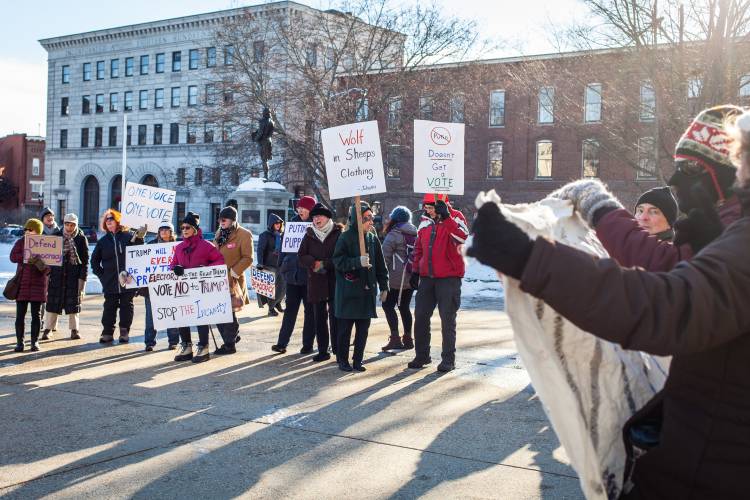 Demonstrators with anti-Donald Trump signs gather outside the State House in Concord the morning New Hampshire’s electors meet to cast their Electoral College ballots for Hillary Clinton, Monday, Dec. 19, 2016. (ELIZABETH FRANTZ / Monitor staff)