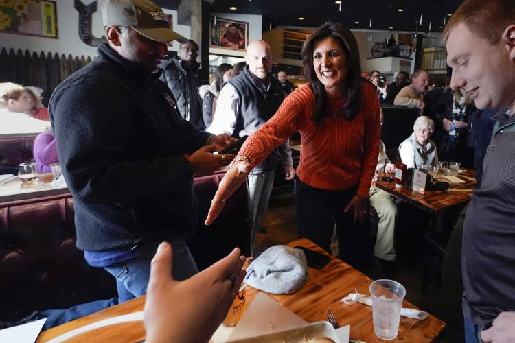 Republican presidential candidate former UN Ambassador Nikki Haley shakes hands with a patron during a campaign stop at a brewery, Monday, Jan. 22, 2024, in Manchester, N.H. (AP Photo/Charles Krupa)