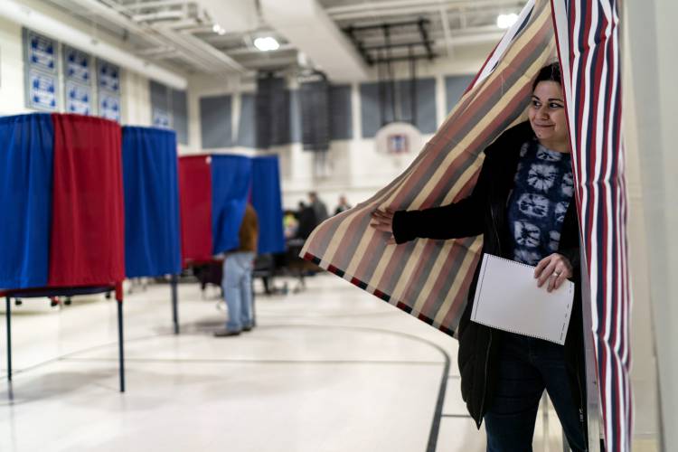 Mary Cullen emerges from a voting booth after filling out her ballot for the New Hampshire presidential primary at a polling site in Manchester, N.H., Tuesday, Jan. 23, 2024. (AP Photo/David Goldman)