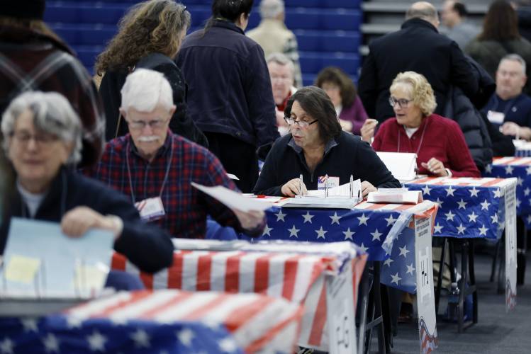 Poll workers check in voters for the presidential primary election at Windham High School, Tuesday, Jan. 23, 2024, in Windham, N.H. (AP Photo/Michael Dwyer)
