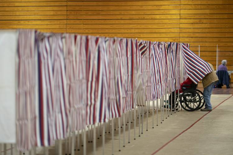 A voters leaves a booth after casting a ballot in the New Hampshire presidential primary at a poling site in Derry, N.H., Tuesday, Jan. 23, 2024. (AP Photo/David Goldman)