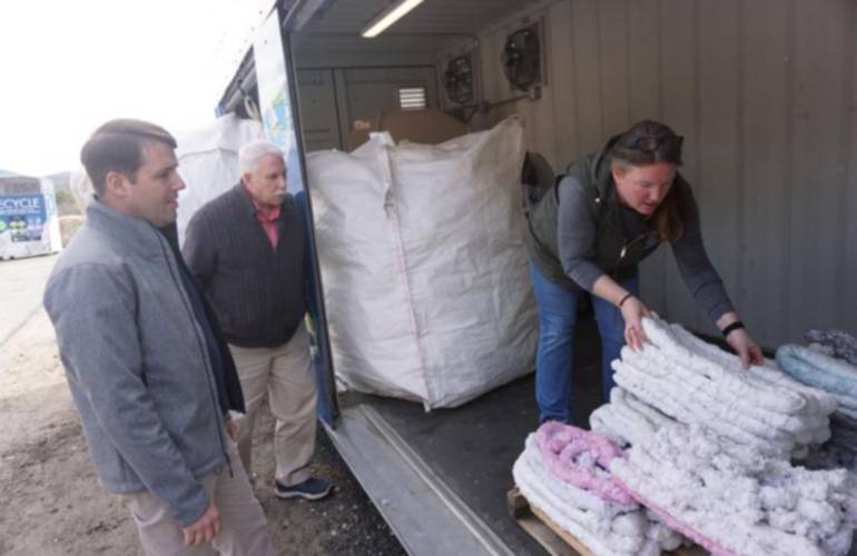 Rep. Chris Pappas, left, attended a presentation in Gilford on April 2. Gilford Department of Public Works Director Meghan Theriault, right, handles the finished product of densified foam as Town Administrator Scott Dunn looks on. The foam recycling program is the first in the state.