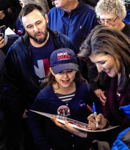 Hannah Kesselring, 10, gets to meet her top candidate, former Gov. NIkki Haley, with her father at Robie’s County Store in Hooksett on Thursday. Haley was sure to come by and say hello to Hannah and sign posters.