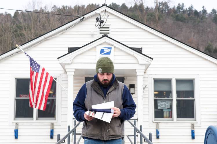 Zach Wood checks his mail after picking it up from the post office in Sharon while delivery is suspended on Dec. 8. Wood said his grandmother and grandfather were both postmasters and they were able to support their family of 12 kids on their salaries. “It did well for them over the years,” he said.