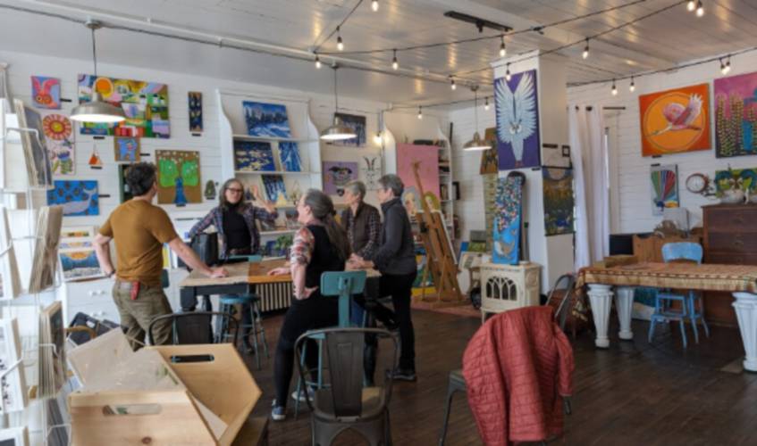 Artists gather around the community table at Three Sisters Gallery in Gorham.