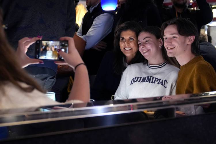 Republican presidential candidate former UN Ambassador Nikki Haley, third from right, poses for a selfie with guests during a campaign stop at Mary Ann's Diner, Friday, Jan. 19, 2024, in Amherst, N.H. (AP Photo/Charles Krupa) 