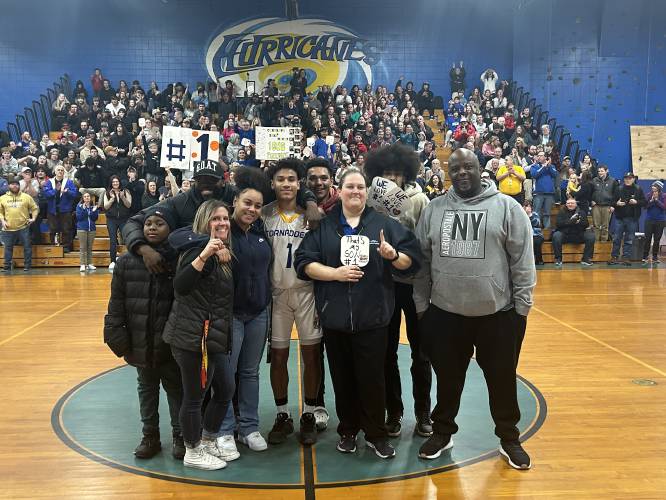 Franklin’s Zeke McCoy (1) poses with his family on the court at Franklin Middle School after scoring his 1,000th career point in Franklin’s 62-27 victory over Moultonborough on Monday night.