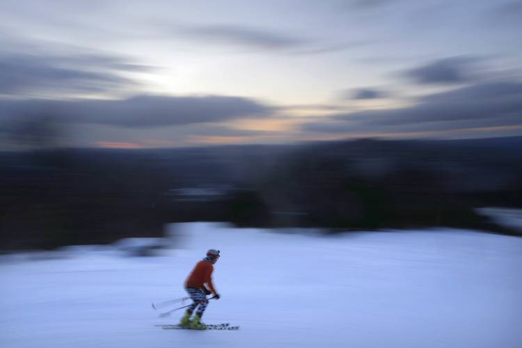FILE - A skier descends Black Mountain of Maine, Feb. 11, 2023, in Rumford, Maine. A new study says U.S. ski areas lost about 5 billion from 2000 to 2019 as a result of human-caused climate change. (AP Photo/Robert F. Bukaty, File)