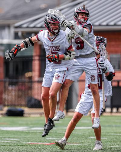 Jaden Haas (left) and Carter Doherty (right) celebrate after Doherty scored the game-winning goal for the Concord High boys’ lacrosse team in Saturday’s victory over Dover, the Tide’s first win of the season. Doherty scored five goals and Haas added four, accounting for all the Tide’s scoring in the 9-8 victory in a game played in Laconia.