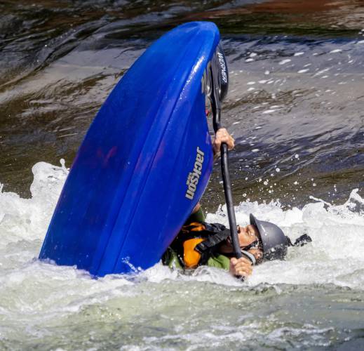 David Plizga of Portland, Maine rides the wave in the manmade competition hole on the Winnipesaukee River at Mill City Park at Franklin Falls in downtown Franklin on Tuesday, July 26, 2022.