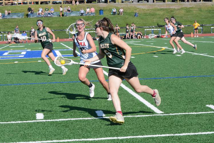 Bishop Brady’s Finley Hollenberg (9) runs the ball up the field and looks to pass to teammate Gabby Heck (10) during a Division III tournament game against Inter-Lakes-Moultonborough last spring.