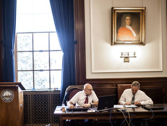 New Hampshire Secretary of State officials Dan Cloutier (left) and John Kiritsy check the ballots matching them with the electronic tallies in the Executive Council Chambers at the State House on the morning after the primary on Wednesday, January 24.