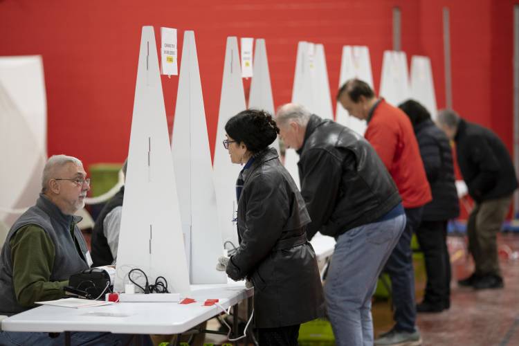 Voters check in to cast ballots in the New Hampshire presidential primary at a polling site in Derry, N.H., Tuesday, Jan. 23, 2024. (AP Photo/David Goldman)