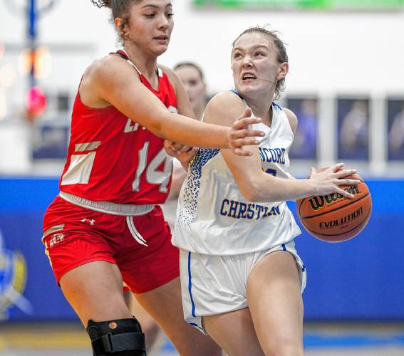 Concord Christian’s Lilli Carlile attacks the basket while Laconia’s Mekhia Burton (14) defends during a game at Concord Christian Academy on Monday. Concord Christian defeated Laconia, 61-38, to improve to 3-0 in its first season in Division II. 