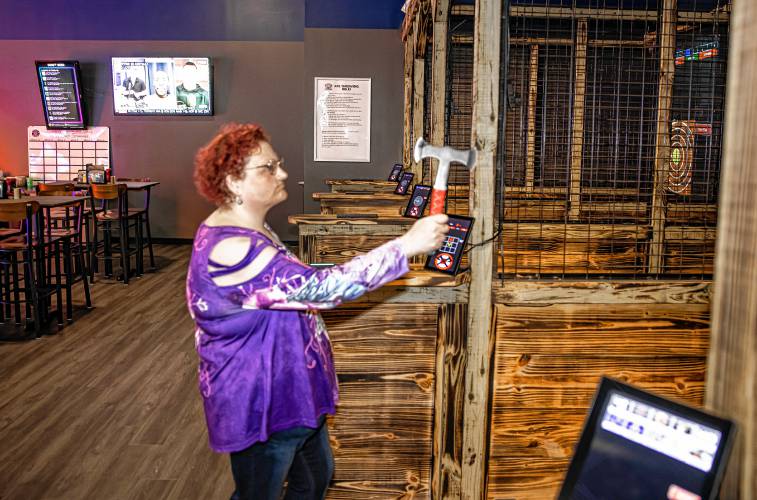 Mindy Welch gets ready to throw an axe at Smitty’s Cinema arcade on Wednesday. Welch said White River Junction doesn’t have similar entertainment options.