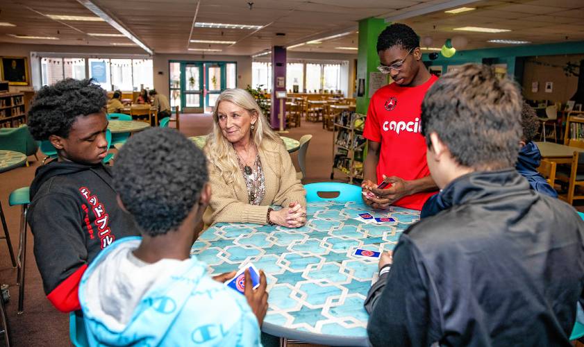 Kathy Kitchell talks with Paul Byage, left, with his friends Ami Gadi, Mehran Asif and Thomas Saysaw at the Rundlett Middle School library on April 18.
