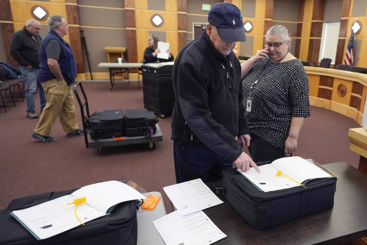 Public witness David Lahey, of Derry, N.H. confirms the serial number of a ballot counting machine with Tina Guilford, Derry town clerk, right, while testing vote counting machines before New Hampshire primary, at the Derry Municipal Center, Tuesday, Jan. 16, 2024. (AP Photo/Charles Krupa)