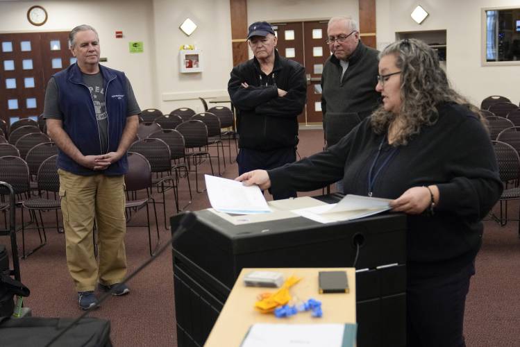 Lisa Hultgren, the Derry, N.H. town moderator, right, explains the mechanics of the ballot counting machines to public witnesses while testing the machines before the New Hampshire primary, at the Derry Municipal Center, Tuesday, Jan. 16, 2024. At rear from left are Derry residents Nick Zaharias, David Lahey and Rep. Richard Tripp, R-N.H. (AP Photo/Charles Krupa)