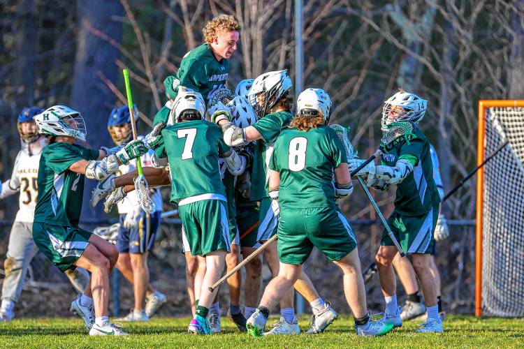 Hopkinton celebrates Merrick Chapin’s game-winning goal in overtime against Bow in the Hawks’ 8-7 win in the season opener on Tuesday.