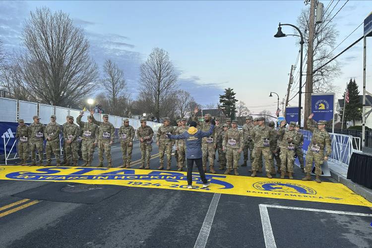 Boston Marathon Race Director Dave McGillivray sends a group of Massachusetts National Guard members across the start line in Hopkinton on Monday, April 15, 2024 to begin the marathon. The start line was painted in honor of the town that has hosted the marathon for the past century. It's the 128th edition of the world’s oldest and most prestigious annual marathon. (AP Photo/Jennifer McDermott)