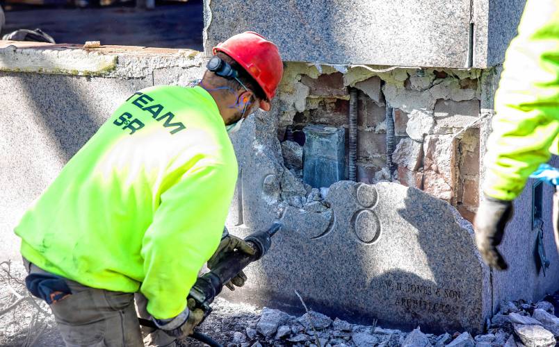 Members of the S&R Demolition team out of Lowell, Massachusetts use a hammer to chip away at the cornerstone of the former DOJ and Mechanics Bank building on North State Street as they search for the time capsule on Tuesday.