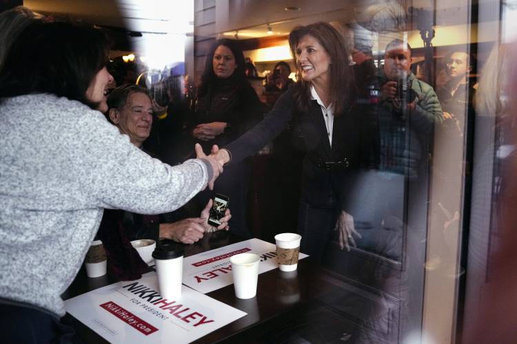 Republican presidential candidate former UN Ambassador Nikki Haley, seen through a storefront window, shakes hands with guests while visiting Kay's Bakery and Cafe, during a campaign stop, Friday, Jan. 19, 2024, in Hampton, N.H. (AP Photo/Charles Krupa)
