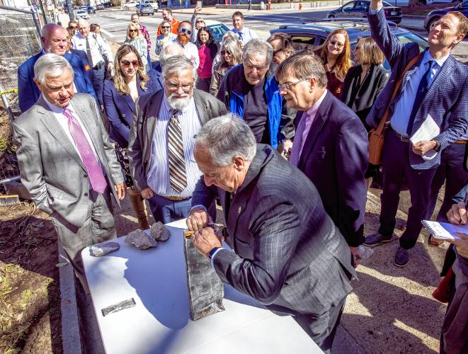 Terence Pfaff, COO of the General Court of NH, opens up the time capsule as the crowd looks on at the former DOJ and Mechanics Bank building on North State Street in Concord on Tuesday, April 9, 2024.