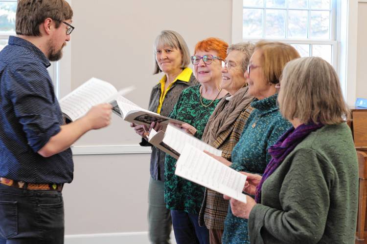 A small group of Kearsarge Chorale singers, with Chair Linda Barnes second from left, rehearse with Artistic Director Alex Ager.