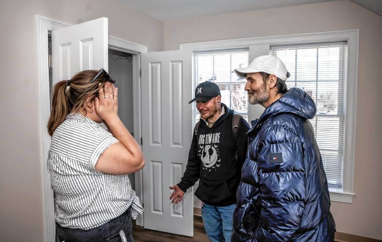 Larry Regan (right) celebrates  with David Lee Josselyn (center) and  Connor Spern of the Concord Coalition to End Homelessness as they inspect one of the eight apartments that will house the homeless at the grand opening  at the Pleasant Street complex on Tuesday, April 23, 2024. Josselyn and Regan have apartments now.