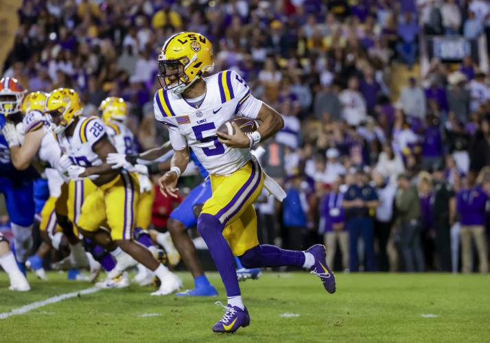 FILE - LSU quarterback Jayden Daniels (5) runs for a touchdown against Florida during the first half of an NCAA college football game in Baton Rouge, La., Saturday, Nov. 11, 2023. Daniels is a possible first round pick in the NFL Draft.(AP Photo/Derick Hingle, File)
