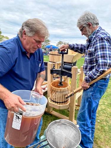 Darryl Peasely, a leader of the Abenaki helping Abenaki hand presses the apples collected from local farms to make cider 