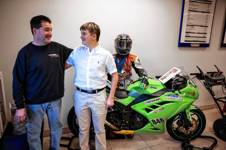 Cole Thompson stands with his dad, Kyle in front of the bike he raced at Daytona that is now displayed at Freedom Cycle in Concord. Thompson has ascended from novice to amateur to compete in races across the region and country and aims to jump to expert races soon.