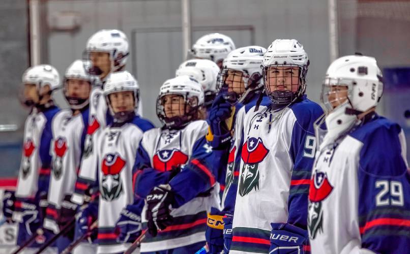 Defenseman Chris Gagnon (9) from John Stark looks at his Stark teammate, goalie Charlie Pierce during introductions on Wednesday before their game against Timberline. The team is made up of players from three are high schools