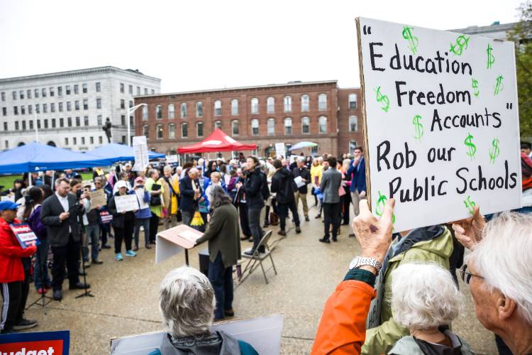 Homemade signs abound at the Fight for Our Future rally at the State House before the budget hearing inside the Representatives Hall on Tuesday, May 6, 2025.