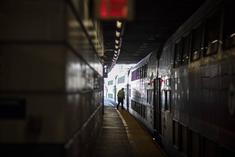 A train employee boards the commuter rail heading to Boston after waiting for passengers, Friday, Nov. 20, 2020, in Providence, R.I.