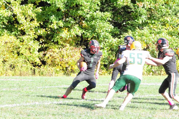 Hillsboro-Deering's Robert King (1) takes a handoff from quarterback Joshuwa Perron (11) during H-D's first ever homecoming football game on its campus on Saturday, Oct. 5, 2024. King ran for 253 yards and four touchdowns, but H-D fell to Bishop Brady, 56-46. 