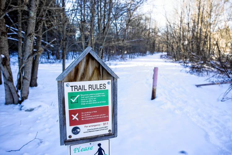 A trail sign along the rail trail on the east side of the Warner  River.