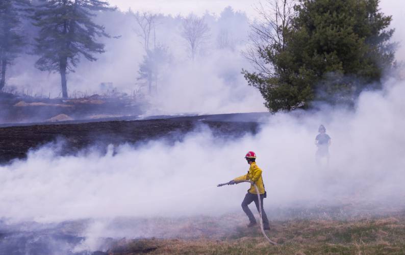 A fire at 100 Chase Farm Road in Hopkinton on Monday afternoon drew firefighters from around the area as flames spread from a garage to surrounding brush and fields.