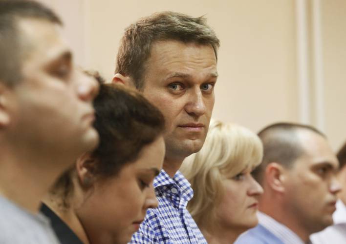 FILE - Russian opposition leader Alexei Navalny, center, and his former colleague Pyotr Ofitserov, foreground, listen to judge in a court in Kirov, Russia, on July 18, 2013. Alexei Navalny, the fiercest foe of Russian President Vladimir Putin who crusaded against official corruption and staged massive anti-Kremlin protests, died in prison Friday Feb. 16, 2024 Russia’s prison agency said. He was 47. (AP Photo/Dmitry Lovetsky, File)