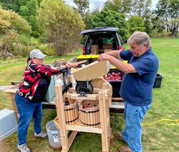 Darryl Peasely, a leader of the Abenaki helping Abenaki hand presses the apples collected from local farms to make cider 