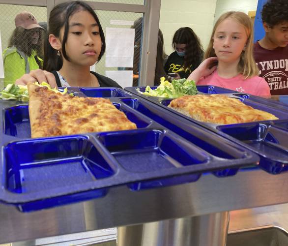 Students get lunch of homemade pizza and caesar salad at the Albert D. Lawton Intermediate School, in Essex Junction, Vt., Thursday, June 9, 2022. The pandemic-era federal aid that made school meals available for free to all public school students — regardless of family income levels — is ending, raising fears about the effects in the upcoming school year for families already struggling with rising food and fuel costs. (AP Photo/Lisa Rathke) Students get lunch of homemade pizza and caesar salad at the Albert D. Lawton Intermediate School, in Essex Junction, Vt., Thursday, June 9, 2022. The pandemic-era federal aid that made school meals available for free to all public school students — regardless of family income levels — is ending, raising fears about the effects in the upcoming school year for families already struggling with rising food and fuel costs. (AP Photo/Lisa Rathke)