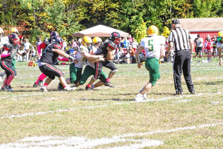 Hillsboro-Deering's Dan Richard (10) rushes up the middle as Bishop Brady's Daniel Shedd (40) and Luke Jackson (55) try to bring him down. Richard ran 186 yards and two touchdowns, but H-D fell to Brady, 56-46, on Saturday, Oct. 5, 2024.