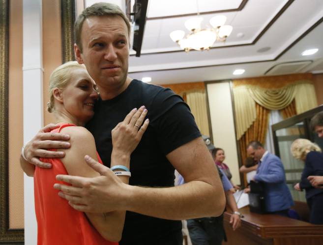 FILE - Russian opposition leader Alexei Navalny, right, embraces his wife Yulia, as he was released in a courtroom in Kirov, Russia, on July 19, 2013. Alexei Navalny, the fiercest foe of Russian President Vladimir Putin who crusaded against official corruption and staged massive anti-Kremlin protests, died in prison Friday Feb. 16, 2024 Russia’s prison agency said. He was 47. (AP Photo/Dmitry Lovetsky, File)