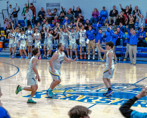 The Kearsarge bench celebrates after Noah Dunlap (42) scored during his senior night on Feb. 6. 