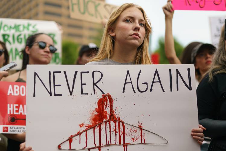 A woman holds a sign to protest the Supreme Court’s decision in the Dobbs v. Jackson Women’s Health case on June 24, 2022, in Atlanta, Georgia. The Court’s decision overturns the landmark 50-year-old Roe v. Wade case, removing a federal right to an abortion. 
