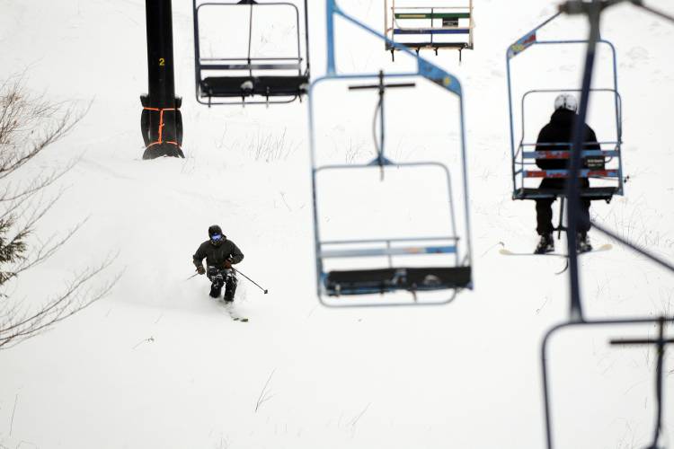 A skier takes advantage of untouched powder under the lift at Whaleback ski area in Enfield, N.H., on Jan. 27, 2015.